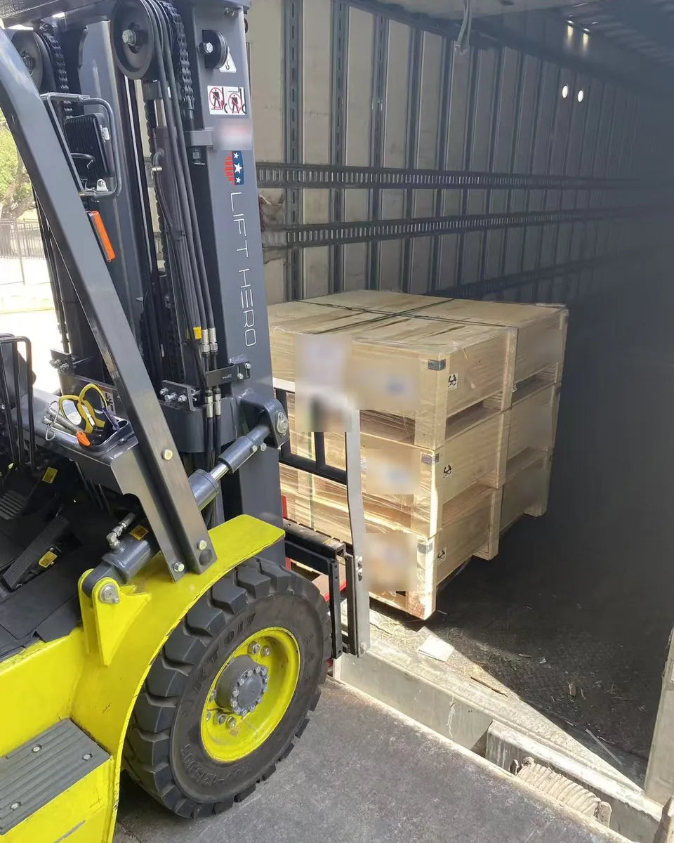 A forklift loading a pallet of crates into a freight trailer.