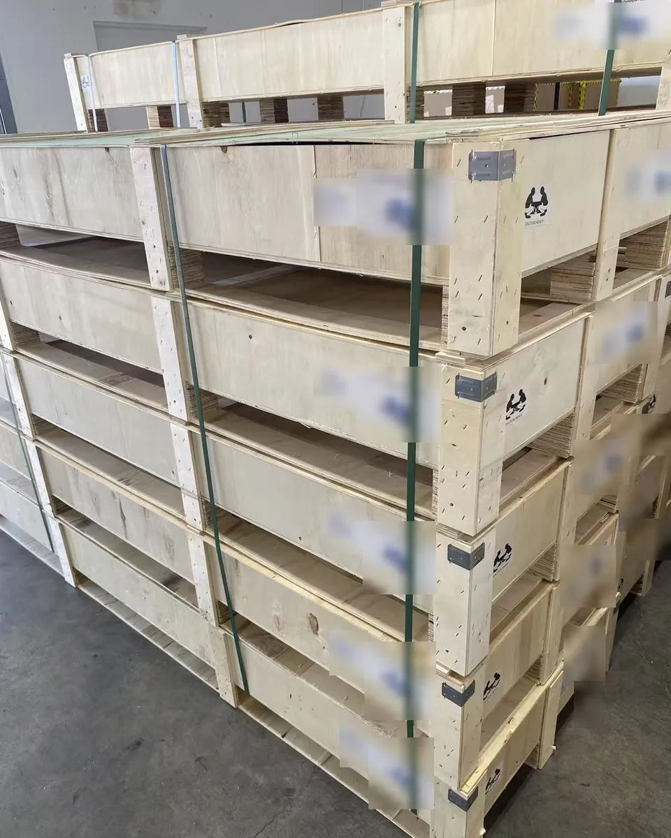 Stacked wooden crates, each holding one picnic table, strapped for shipping.